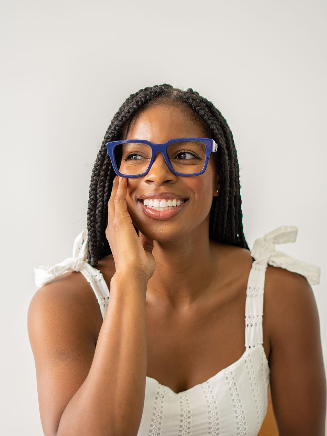Smiling woman wearing blue KLY Eyecare frames